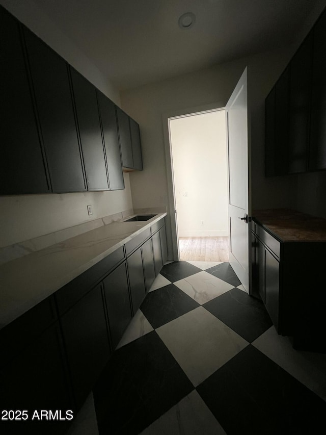 kitchen featuring a sink and dark cabinetry