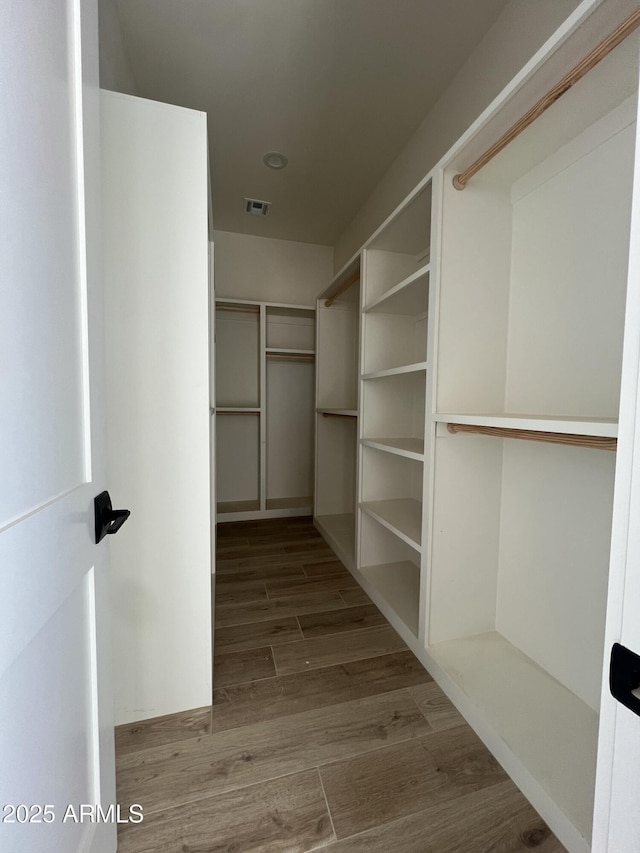 spacious closet featuring wood finished floors and visible vents