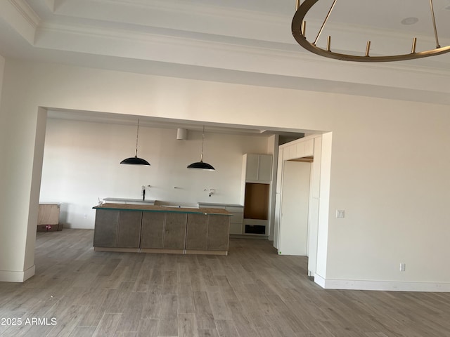 kitchen with decorative light fixtures, light wood-style flooring, a center island, and baseboards