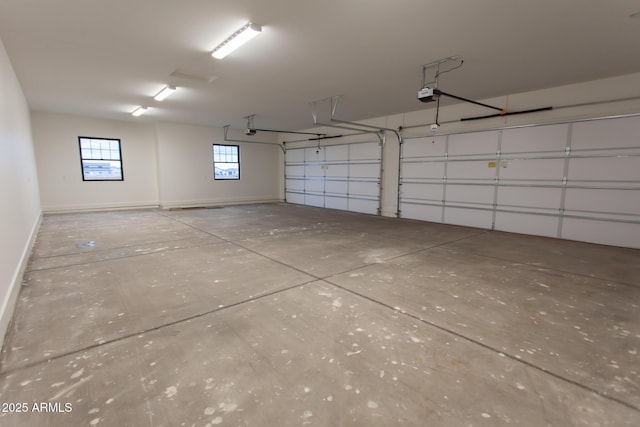 garage featuring a garage door opener and baseboards