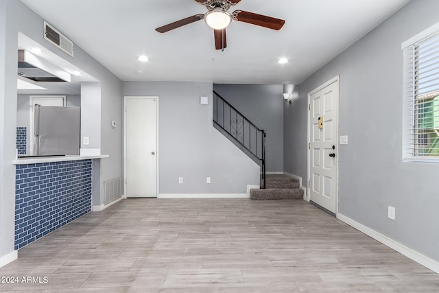 entrance foyer with tile walls, ceiling fan, and light hardwood / wood-style floors