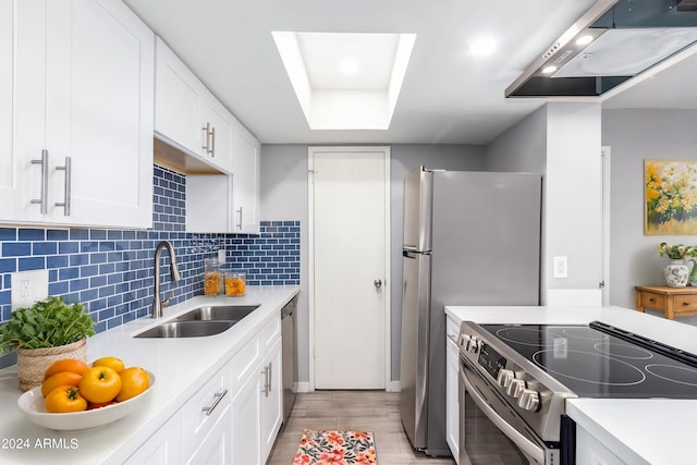 kitchen featuring tasteful backsplash, stainless steel appliances, sink, white cabinetry, and light wood-type flooring