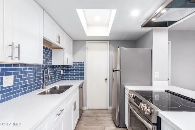 kitchen with appliances with stainless steel finishes, tasteful backsplash, extractor fan, sink, and white cabinets