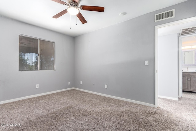 carpeted spare room featuring ceiling fan