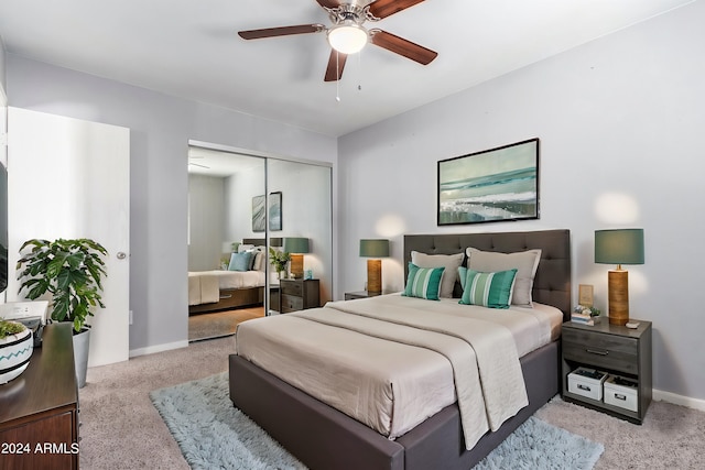 bedroom featuring light carpet, ceiling fan, and a closet