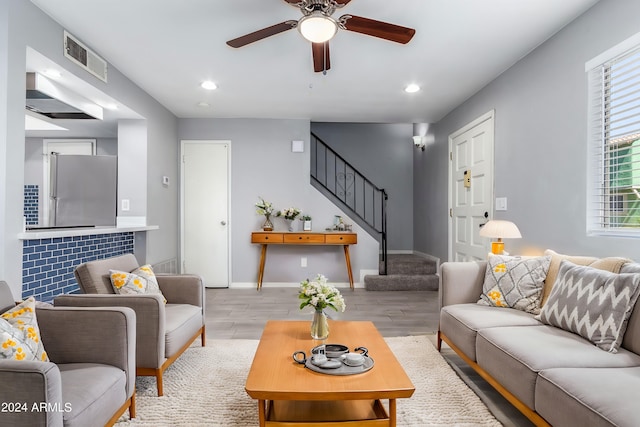 living room with ceiling fan and light hardwood / wood-style flooring