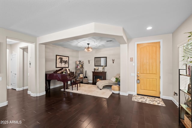 3766 E Ringtail Way, Phoenix, AZ 85050 - foyer entrance featuring dark wood-style floors, recessed lighting, and a warm lit fireplace