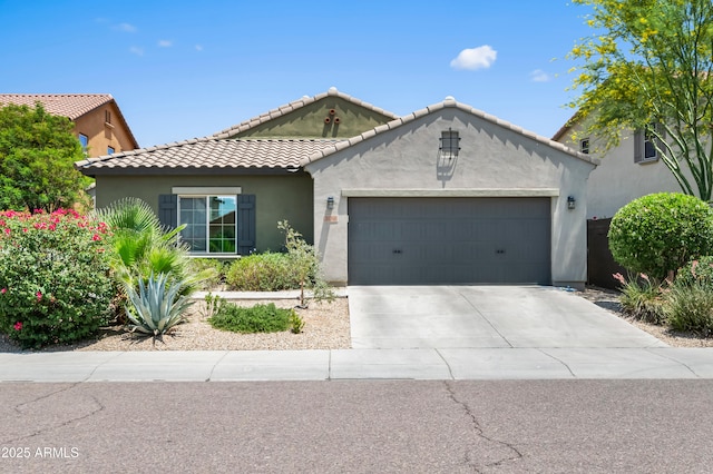 3766 E Ringtail Way, Phoenix, AZ 85050 - mediterranean / spanish-style home with stucco siding, an attached garage, concrete driveway, and a tiled roof