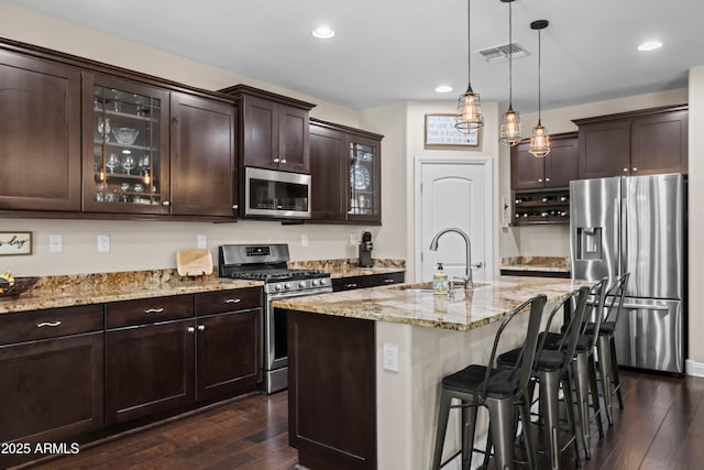 3766 E Ringtail Way, Phoenix, AZ 85050 - kitchen featuring appliances with stainless steel finishes, dark wood-style flooring, dark brown cabinetry, light stone counters, and recessed lighting