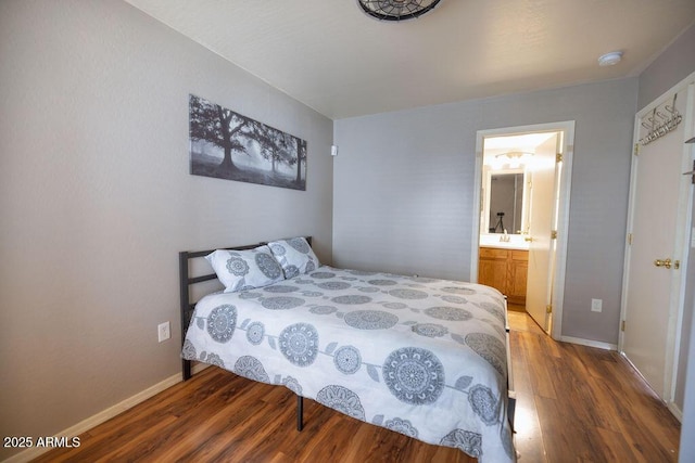 bedroom with connected bathroom and hardwood / wood-style floors