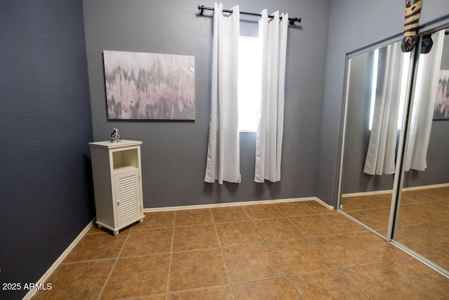 unfurnished bedroom featuring tile patterned floors and a closet