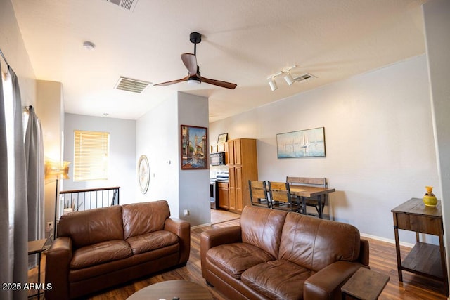 living room with light hardwood / wood-style floors and ceiling fan