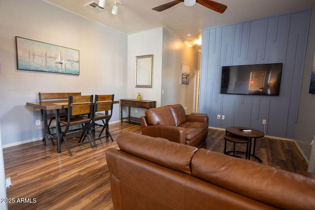 living room with dark wood-type flooring and ceiling fan