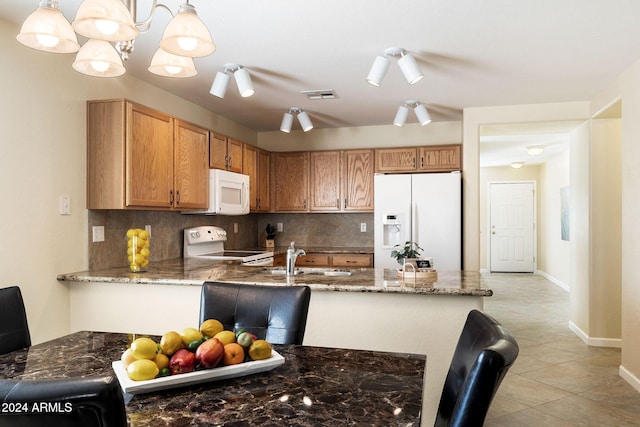 kitchen with sink, backsplash, kitchen peninsula, pendant lighting, and white appliances