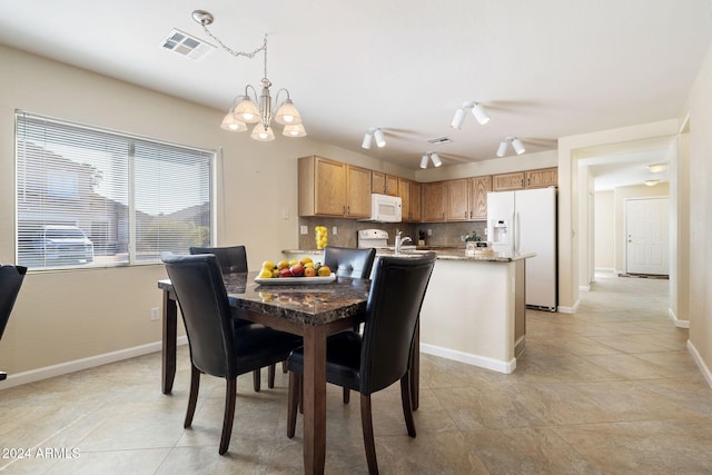 dining area featuring track lighting, a notable chandelier, and light tile patterned flooring