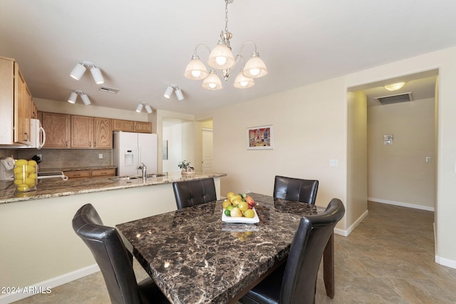 dining space featuring sink and an inviting chandelier