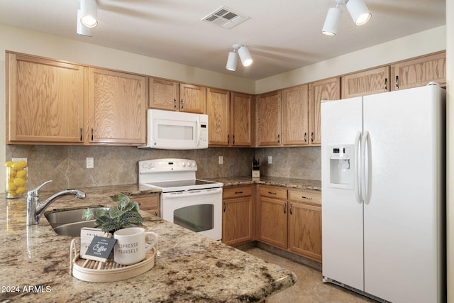 kitchen featuring decorative backsplash, light stone counters, sink, and white appliances