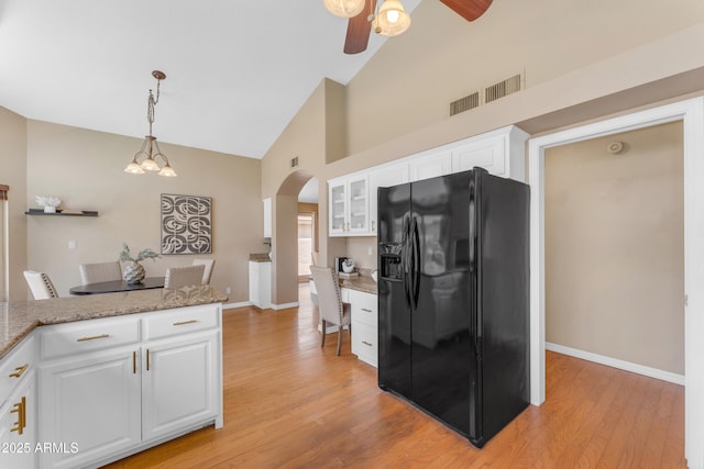 5822 W Abraham Ln, Glendale, AZ 85308 - kitchen with black refrigerator with ice dispenser, arched walkways, ceiling fan, high vaulted ceiling, and white cabinetry