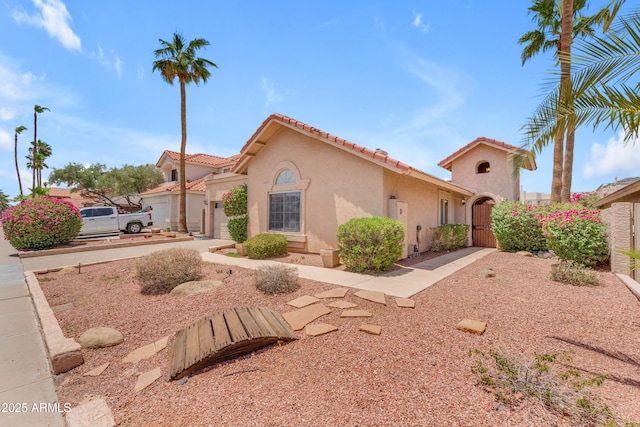 5822 W Abraham Ln, Glendale, AZ 85308 - mediterranean / spanish-style house featuring an attached garage, stucco siding, a tiled roof, and a gate