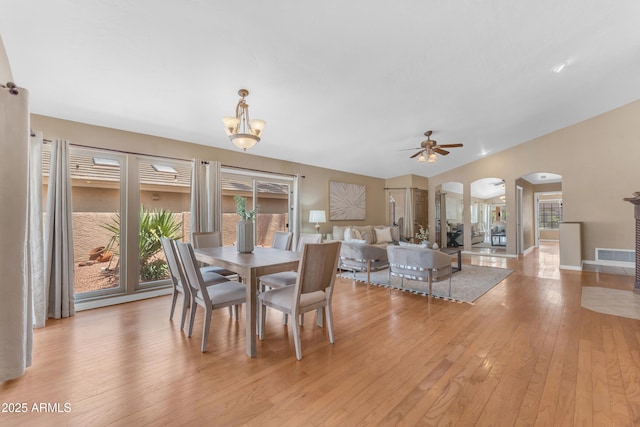 5822 W Abraham Ln, Glendale, AZ 85308 - dining room with arched walkways, light wood-style floors, ceiling fan, a chandelier, and vaulted ceiling