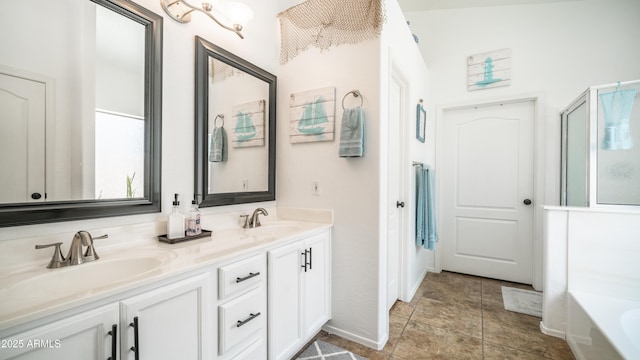 bathroom featuring double vanity, a washtub, and a sink