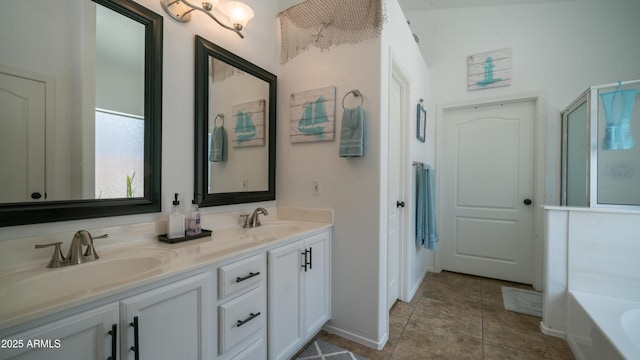 bathroom with double vanity, a garden tub, a sink, and tile patterned floors