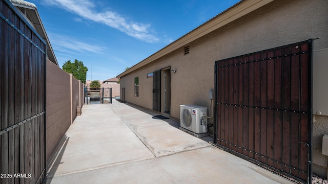 view of home's exterior with ac unit, stucco siding, a gate, a patio area, and fence