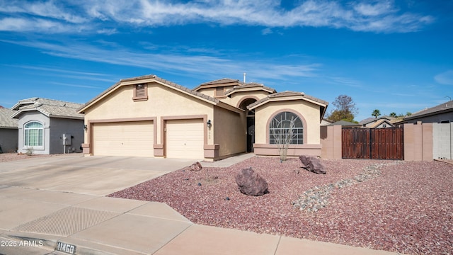 view of front facade with driveway, an attached garage, fence, and stucco siding