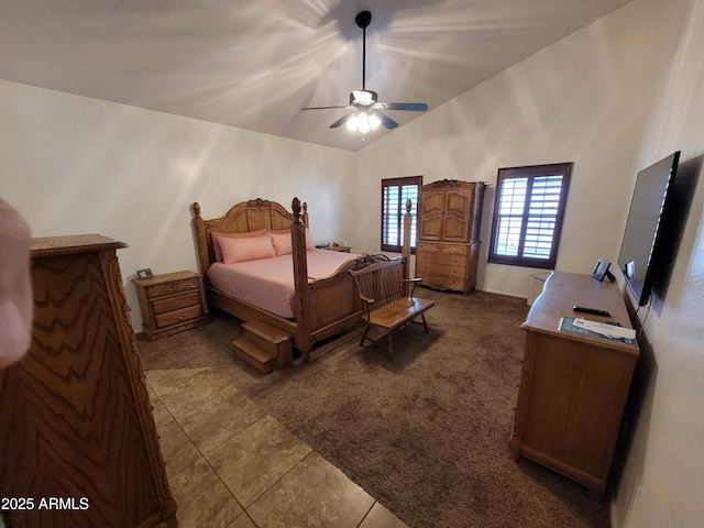 bedroom with a ceiling fan, dark tile patterned flooring, dark carpet, and high vaulted ceiling