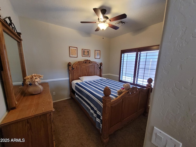 bedroom with visible vents, dark carpet, and a ceiling fan