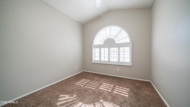 carpeted spare room with vaulted ceiling, baseboards, and ceiling fan