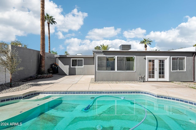 view of swimming pool with french doors and a patio area