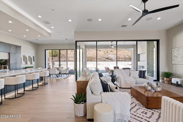 living room with ceiling fan and light wood-type flooring