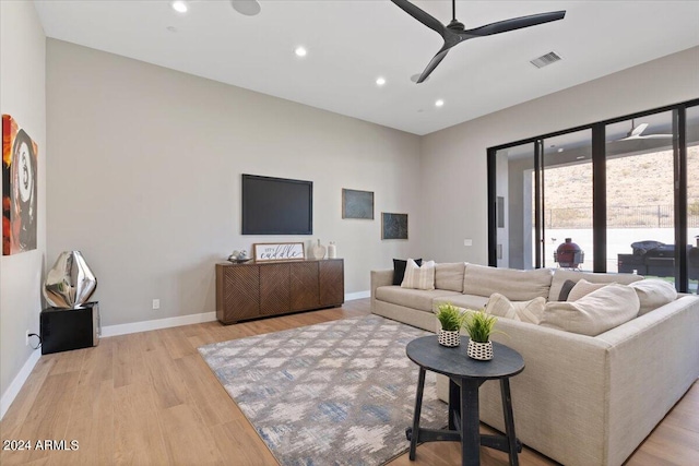 living room with light hardwood / wood-style flooring and ceiling fan