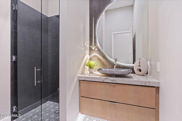 bathroom with vanity, a shower with shower door, and tile patterned flooring