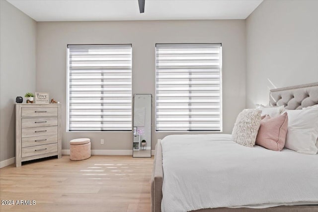 bedroom with multiple windows, light wood-type flooring, and ceiling fan