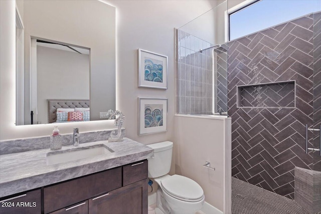 bathroom featuring vanity, toilet, and tiled shower