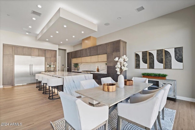 dining room featuring sink and light hardwood / wood-style flooring