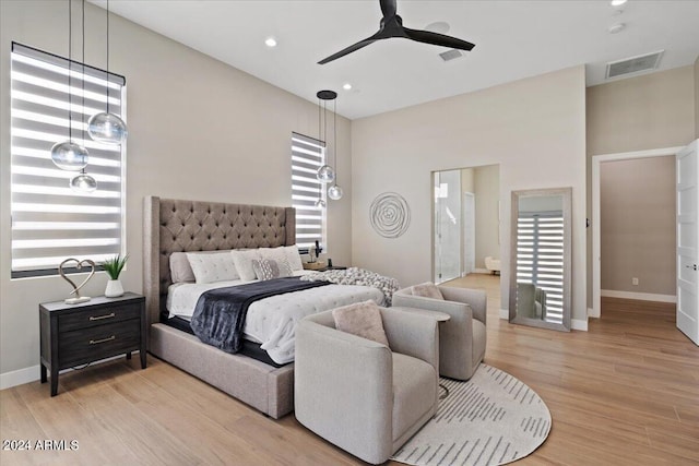 bedroom featuring ensuite bathroom, light hardwood / wood-style floors, and ceiling fan