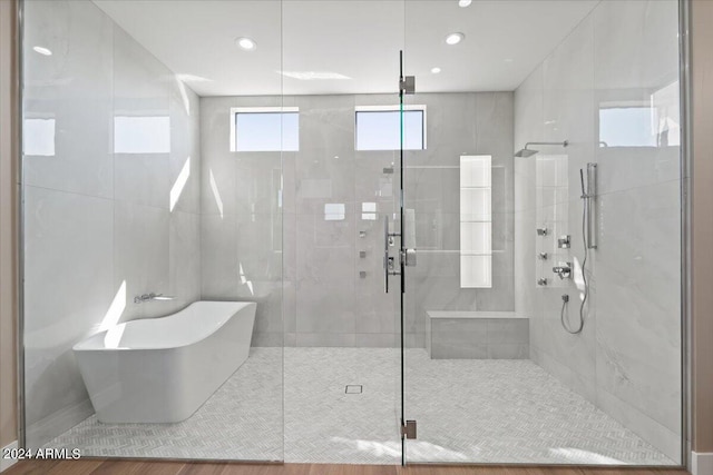 bathroom with hardwood / wood-style flooring and independent shower and bath