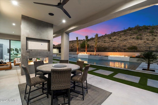 patio terrace at dusk with pool water feature and ceiling fan