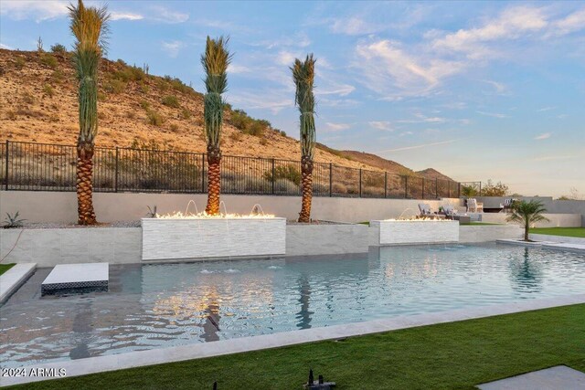 view of swimming pool with pool water feature and a mountain view