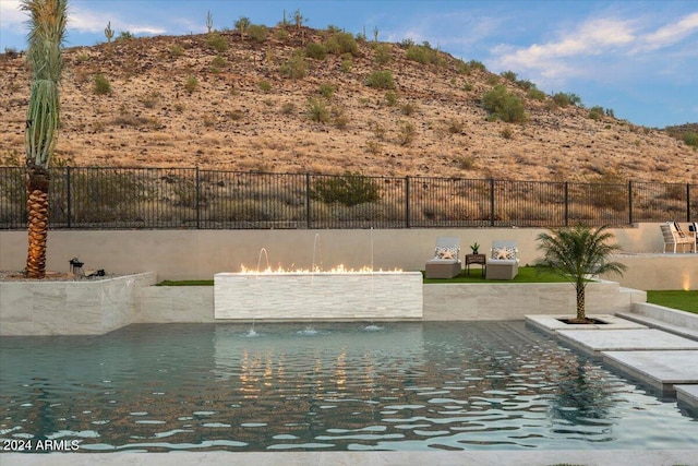 view of pool with an outdoor living space, pool water feature, and a patio area