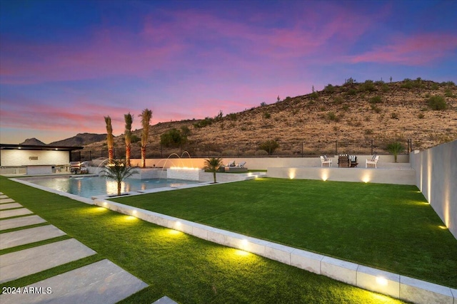 yard at dusk with pool water feature, a patio, and a fenced in pool