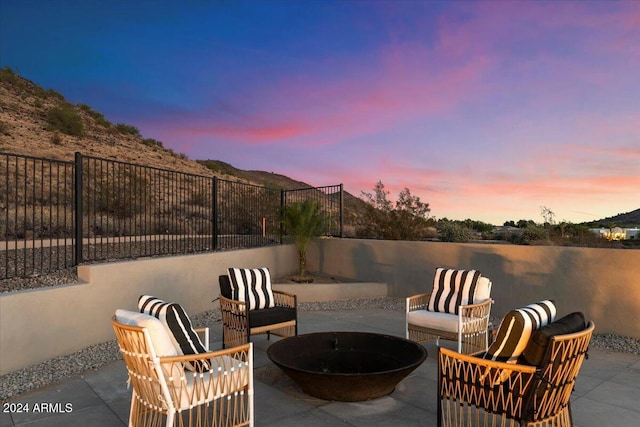 patio terrace at dusk featuring an outdoor living space with a fire pit