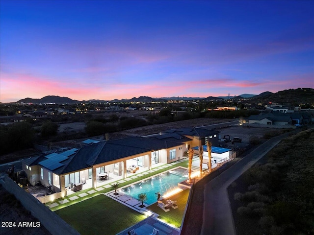 pool at dusk featuring a patio area and a mountain view