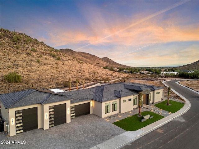 view of front facade featuring a garage, a mountain view, and solar panels