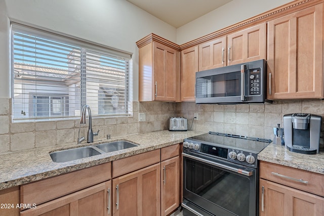 kitchen with light stone countertops, stainless steel electric range oven, sink, and tasteful backsplash