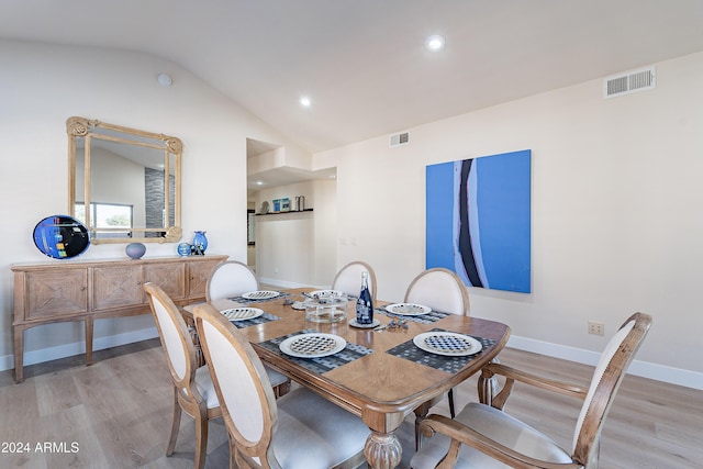 dining space with light hardwood / wood-style floors and lofted ceiling