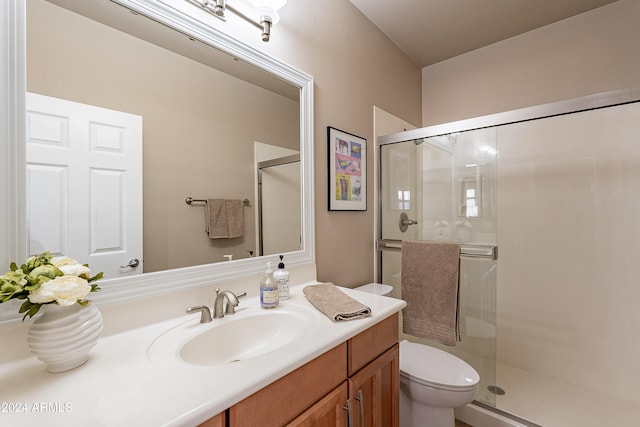 bathroom featuring vanity, toilet, and walk in shower